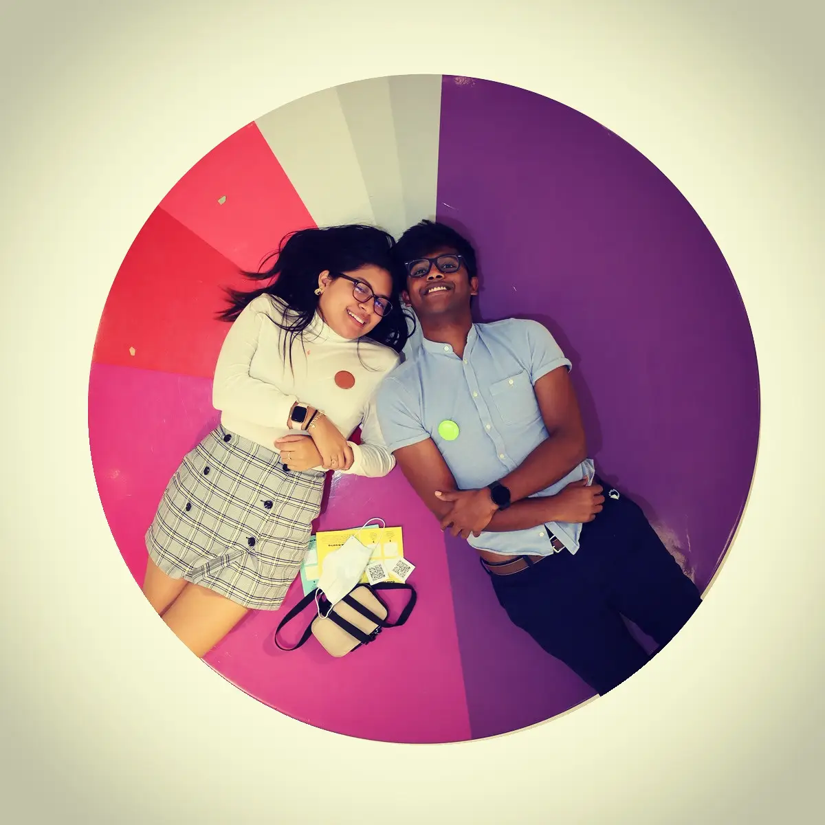 Tiffany and Aravind lying on a colorful art installation